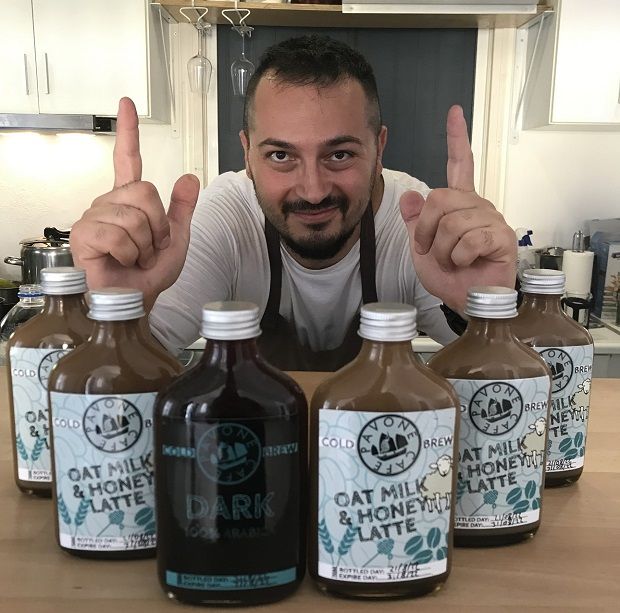 Ο Κώστας Χριστοδούλου στην κουζίνα του εμφιαλώνει καφέ σκέτο και καφέ latte με γάλα βρώμης και μέλι